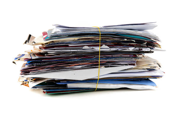istock Junk mail stacked high of unpaid bills closeup white isolated background. 1307313962