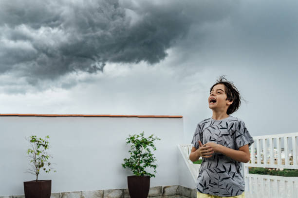 istock Boy playing in the yard during stormy sky 1307317602