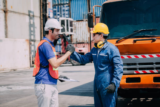 istock worker staff shaking hand for sucess working at Container. workers prepare export products. Container Shipping Logistics Engineering of Import Export Transportation Industry 1307321883