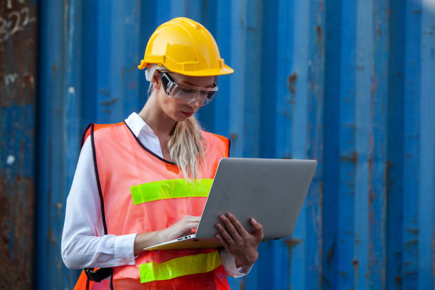 istock woman working with laptop in cargo container. Containers box from Cargo freight ship for import export. Business logistic concept, Import and export concept 1307322747