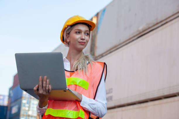 istock woman working with laptop in cargo container. Containers box from Cargo freight ship for import export. Business logistic concept, Import and export concept 1307323335