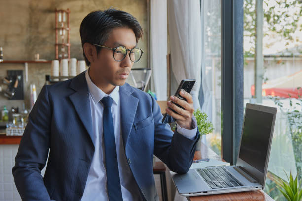 istock Front Right Asian Businessman Wear Glasses Using Smartphone 1307326328