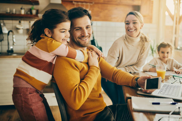 istock Happy working father and his daughter embracing at home. 1307328077