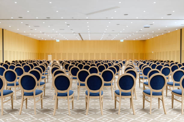 rear view of an empty lecture hall with navy blue chairs and wood paneling walls. - event convention center business hotel imagens e fotografias de stock