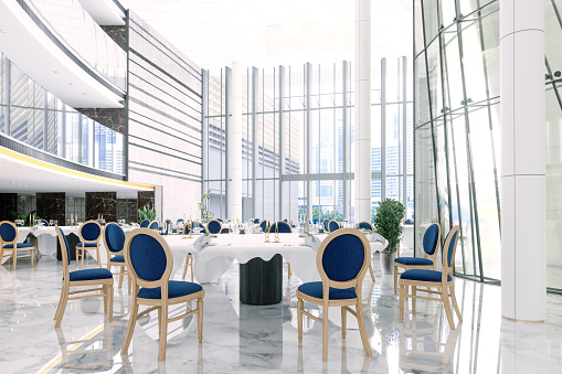 Interior Of A Banquet Hall In A Hotel Or In A Luxury Restaurant With Round Tables And Navy Blue Chairs.