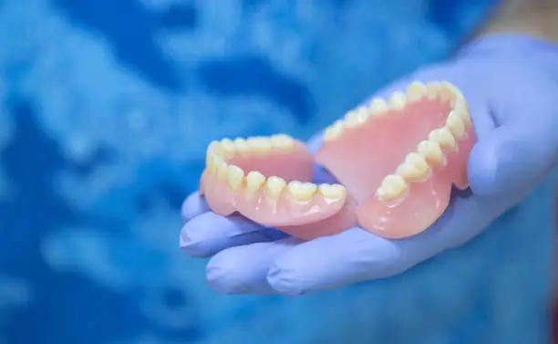 Close up view of dentist hands showing denture