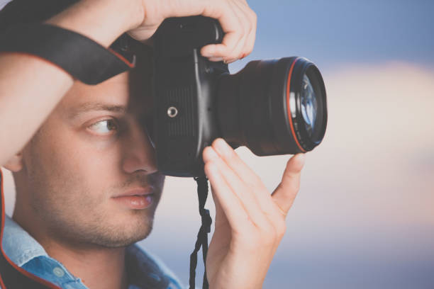 istock Handsome young photographer using his modern DSLR outdoors 1307332223