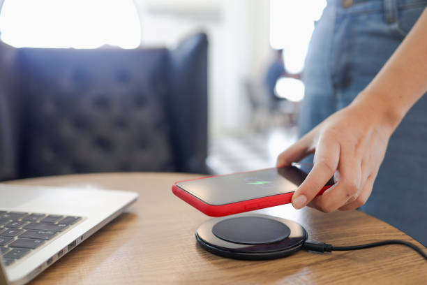 istock Charging mobile phone battery with wireless charging device in the table. Smartphone charging on a charging pad. Mobile phone near wireless charger Modern lifestyle concept. 1307336301