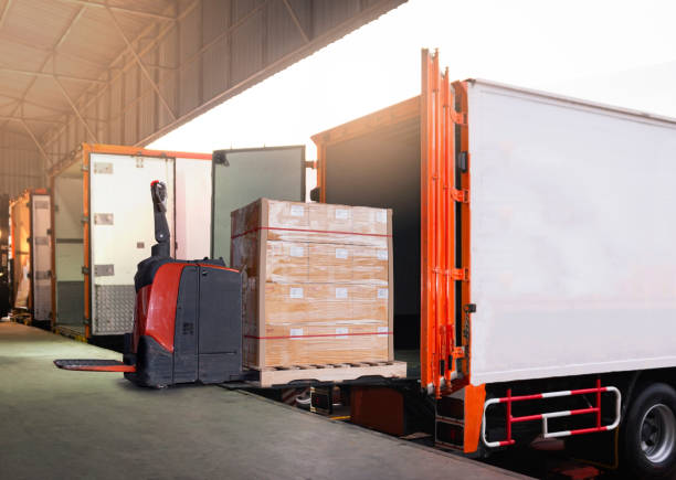 istock Electric Forklift Loading Shipment Boxes into Cargo Container. Cargo Trailer Truck Parked Loading at Dock Warehouse. Delivery Service. Shipping Warehouse Logistics. Freight Truck Transportation. 1307338085
