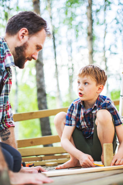 istock Father and son building tree house at backyard 1307338353