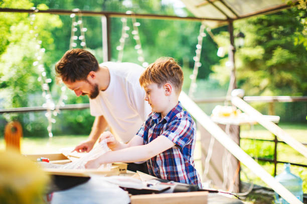 istock Father and son building tree house at backyard 1307338374