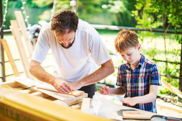 istock Father and son building tree house at backyard 1307338375