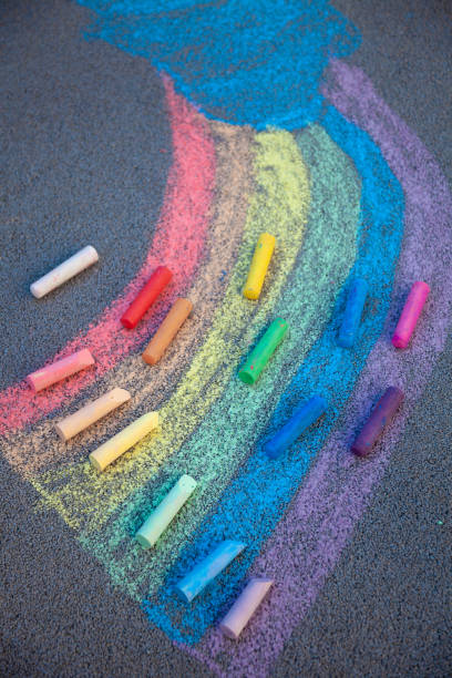 istock Chalk drawing. A rainbow painted on the asphalt with multicolored large crayons 1307340605