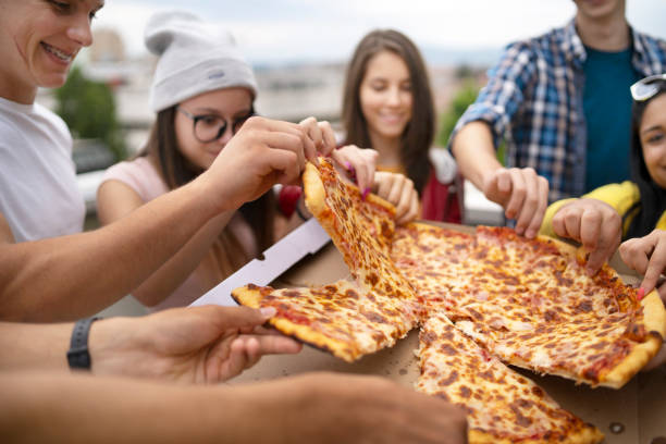 istock Time for snack. Happy students eating pizza together on a party 1307341836