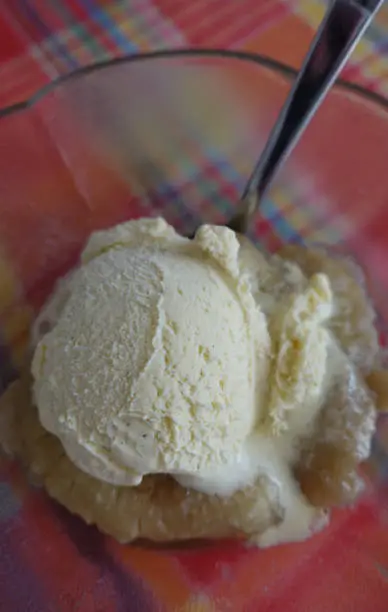 Vanilla ice cream on flambéed bananas in a glass ice cream cup