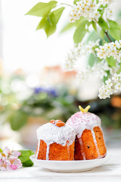 istock Concept of Easter holiday. Two decorated easter cakes on a plate with apple blossom. In the background, blurred plants and flowers. Vertical orientation. Copy space 1307345172