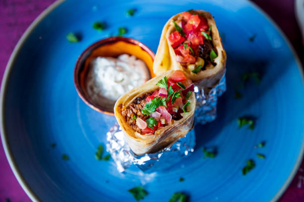 Burritos stuffed with ground beef and vegetables on a plate