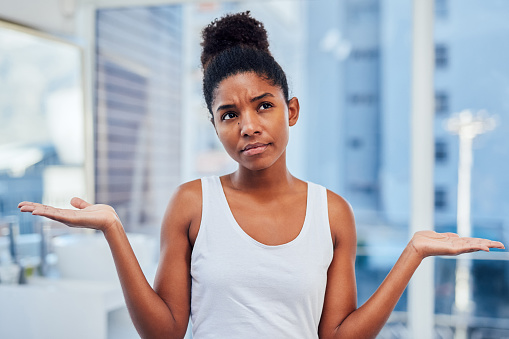 Cropped shot of a woman looking indecisive while standing in the bathroom at home