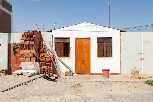 Paracas, Peru - April 15, 2014: A humble little house of the local Paracas inhabitants, unpainted and with some lack of maintenance, in the Chaco area, on a sunny and scorching day.