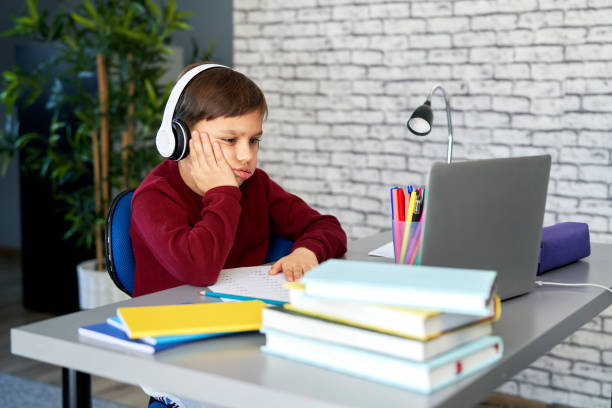 istock Tired schoolboy sitting during homeschooling 1307354877