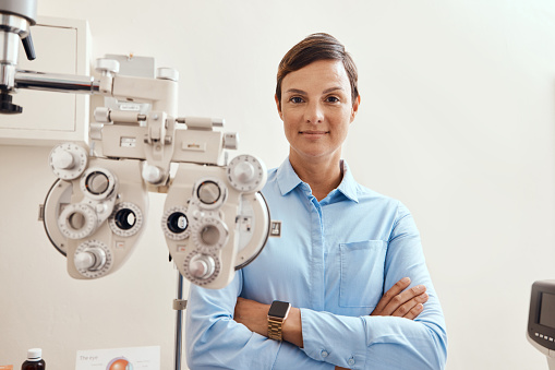 Portrait of a confident woman using an optical refractor in an optometrist’s office