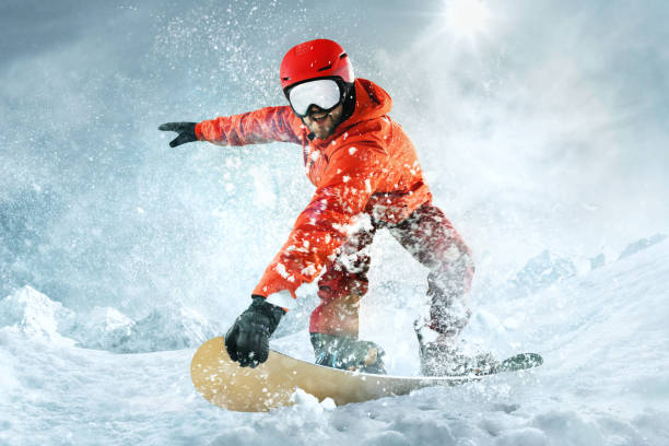 snowboarder cabalgando por el aire con cielo azul profundo en el fondo. el deportista de snowboard volando en acción y movimiento de nieve - extremal fotografías e imágenes de stock