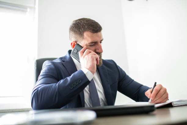 istock Businessman takling on phone and witing notes 1307359944