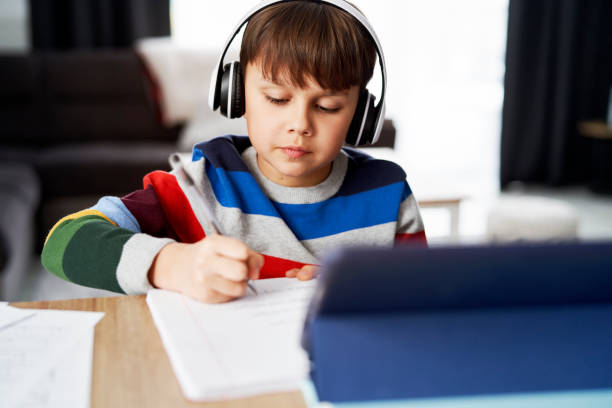 istock Schoolboy in headphone during homeschooling 1307360118