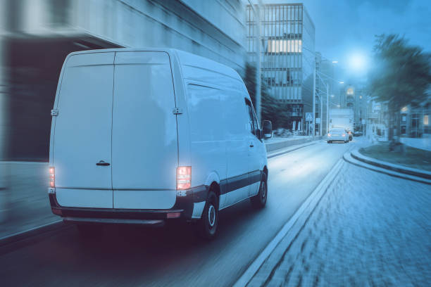 istock Cargo van driving through a city at night 1307361072