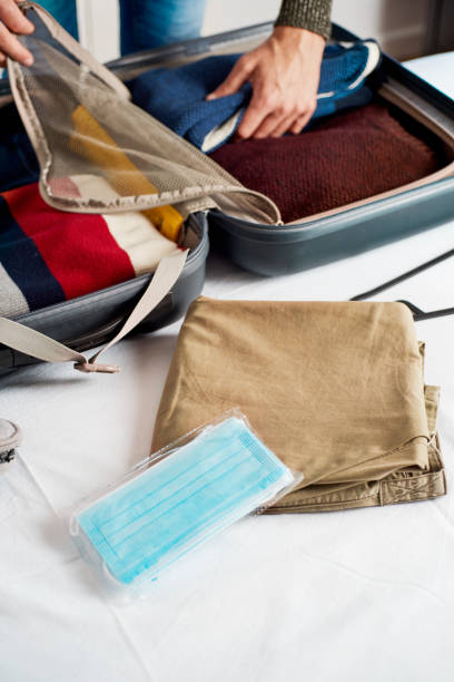istock face masks and man packing in his suitcase 1307361075