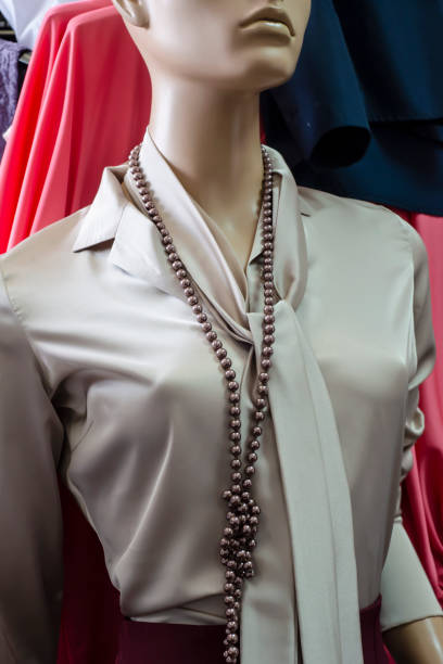istock Silk blouse with a mannequin collar. Long beads and a tie around the neck. 1307361299
