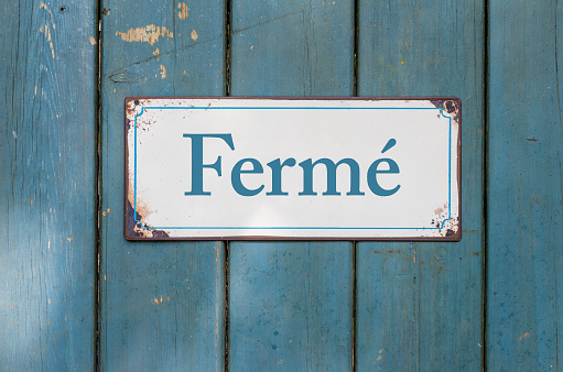Old sign with the inscription Closed in french - Fermé