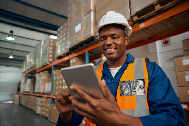 istock Smiling portrait of a african male worker checking the orders for delivery using digital tablet in warehouse 1307362917