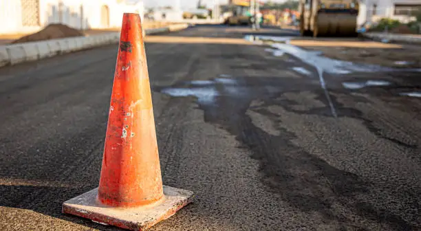 Photo of Close up of an orange traffic cone on the road.