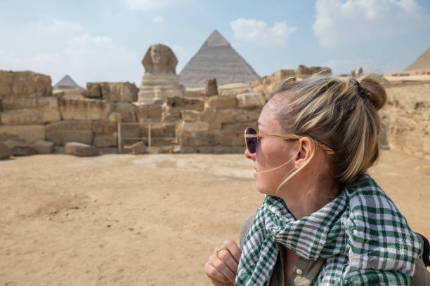 istock Woman contemplates the Sphinx and pyramids in Cairo, Egypt 1307365177