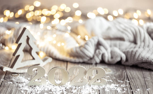 istock Cozy Christmas composition with number 2022 and decor details on blurred background with bokeh. 1307365377