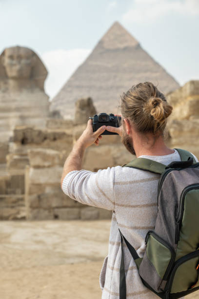 turista maschio scatta foto delle piramidi in egitto - giza plateau immagine foto e immagini stock