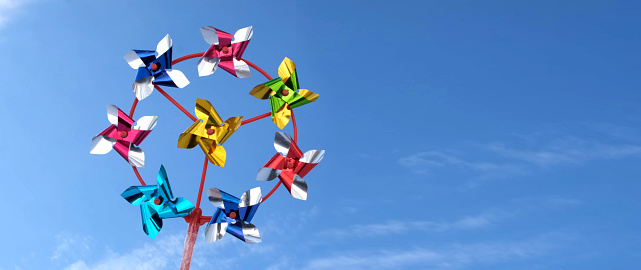 Pinwheel swirling wind on blue sky background. Windmill concept for environmental conservation