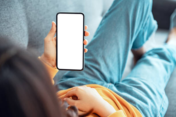 Close up of woman hand holding smart phone with blank copy space white screen background for create content. Close up of woman hand holding smart phone with blank copy space white screen background for create content. looking over shoulder stock pictures, royalty-free photos & images