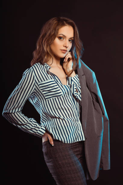 istock Beautiful brunette model posing in shirt and holding her jacket 1307366910