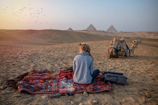 기자 피라미드에서 일몰을 감상하는 여성, 사하라 사막을 가로질러 바라본다 - giza plateau 이미지 뉴스 사진 이미지