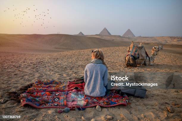 Woman Watches Sunset At The Giza Pyramids She Looks Across The Sahara Desert Stock Photo - Download Image Now