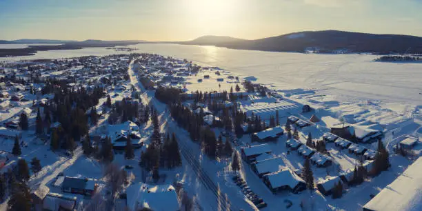 Aerial view of Jukkasjärvi in Kiruna Municipality in the province of Lapland in northern Sweden. Jukkasjärvi is a popular tourist destination for winter activities like dog sledding, watching the northern lights and visiting the Ice Hotel, seen here on the right.