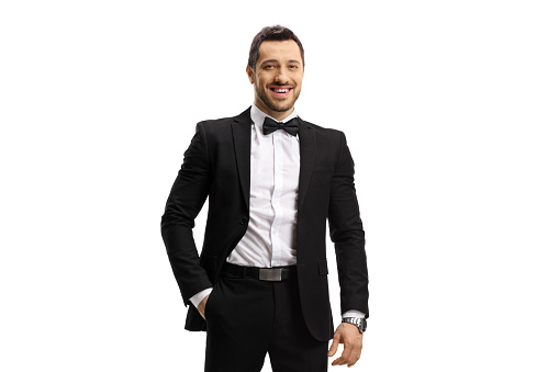 Young man in a suit and bow tie posing with hand in pocket isolated on white background