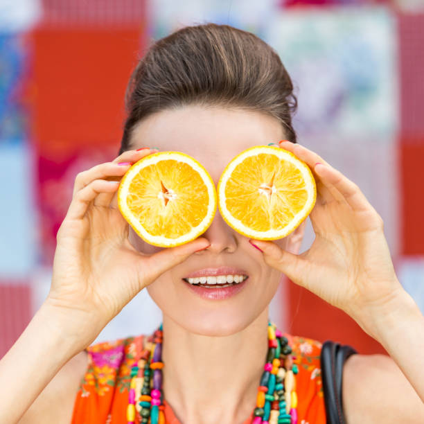 istock woman holding oranges 1307371236