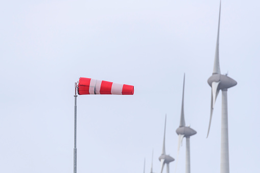 Wind sock in front of wind turbines in a storm at the shore of the IJsselmeer in the Noordoostpolder, Flevoland, The Netherlands.