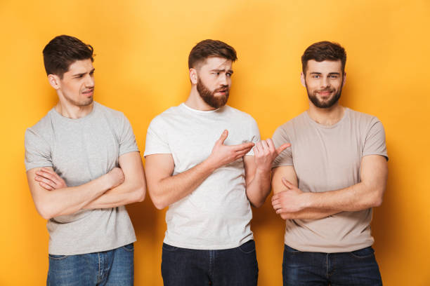istock Two young upset men looking at their male friend 1307372602
