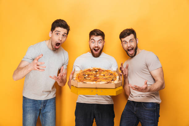 istock Three young joyful men holding a big pizza 1307372730