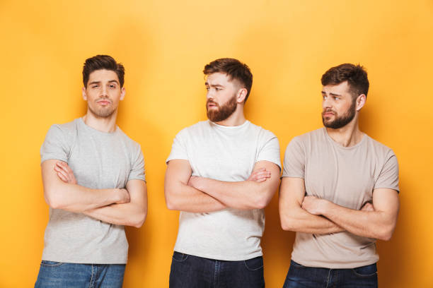 istock Two young upset men looking at their male friend 1307372755
