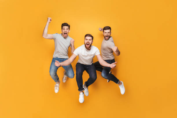 Three young happy men jumping together Three young happy men jumping together isolated over yellow background three amigos stock pictures, royalty-free photos & images